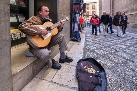 Granada, SPAIN - 16 february 2013   Guitarist sitting on the sill of the Museum JosÃ© Guerrero against the Royal Chapelのeditorial素材
