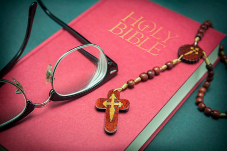 Glasses adjusted on the holy bible and beads