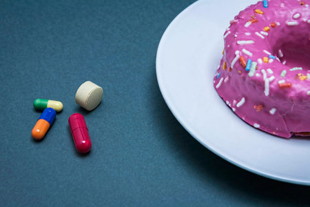 Various medicines to combat diabetes along with a sweet cake, concept of disease of hyperglycemia or...