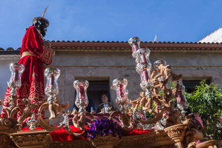 Brotherhood of Jesus corsage, Woman in balcony looking at Christ on the throne during Holy week procession, Jaen province, Andalusia, Spainのeditorial素材
