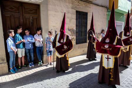 Set of boys watching Holy week procession, Spain, take in Linares, Jaen province, Spain