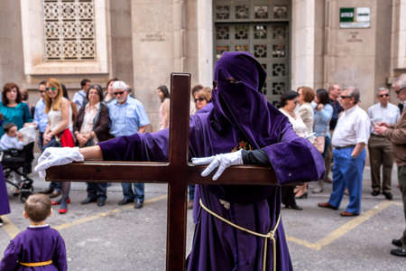 Penitent posed holding his cross during Holy week procession, Spainのeditorial素材