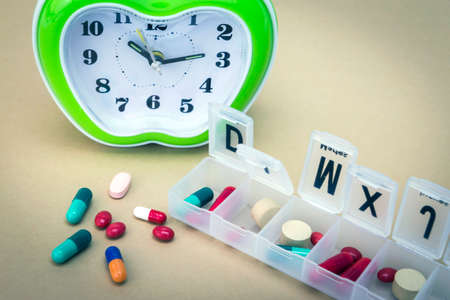 some pills in a pillbox, daily medication treatmentの写真素材