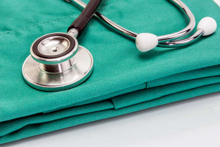 Doctor coat with stethoscope on the deskの写真素材