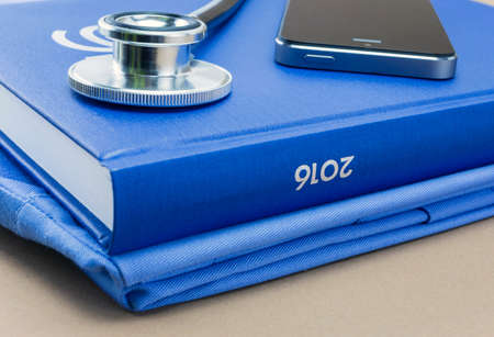 stethoscope and a book on brown backgroundの写真素材