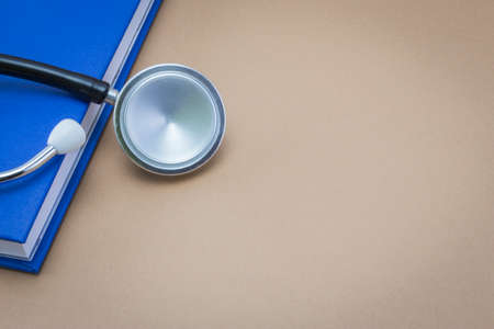 stethoscope and a book on brown backgroundの写真素材