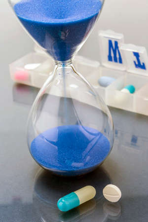 some pills and red clock, daily medication treatment