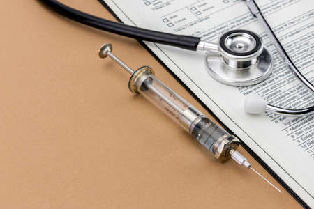 Test medication and stethoscope, Old Syringe isolated on brown backgroundの写真素材