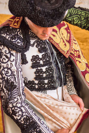 Andujar, SPAIN - September 7, 2014: Spainish bullfighter Miguel Abellan putting itself the walk cape in the alley before going out to bullfight, typical and very ancient tradition in Andujar, Spainのeditorial素材