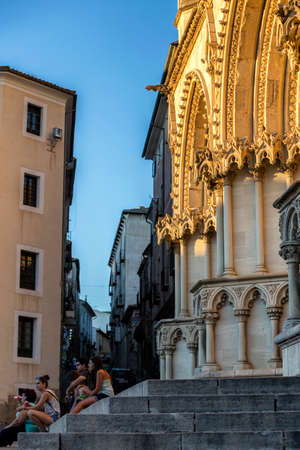CUENCA, SPAIN - APRIL 2, 2016: Tourists rest in the stairs of the cathedral of Cuenca to the evening, The cathedral is dedicated to St Julian, gothic english-norman style, XII century, Cuenca, Spainのeditorial素材