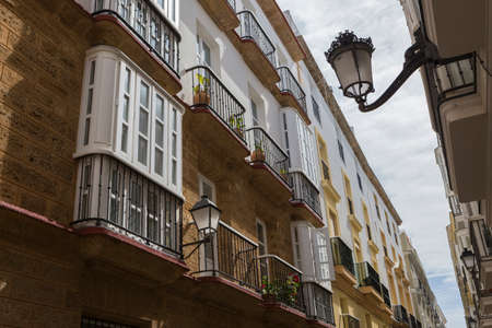 Cadiz Spain- March 31: Detail of balconies and large windows on the time of the nineteenth century, Narrow street with traditional architecture in Cadiz, Andalusia, southern Spainのeditorial素材