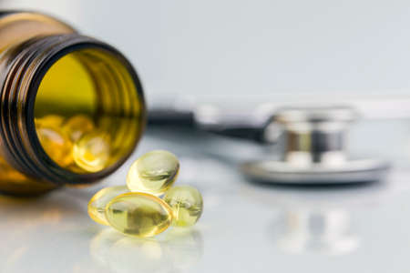 bottle with capsules with olive oil isolated on a white backgroundの写真素材