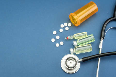 stethoscope, pills, vials in medical room on blue background top view mockupの写真素材