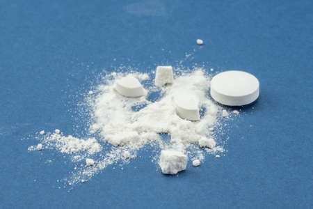 Still life of pills and its powder on blue backgroundの写真素材