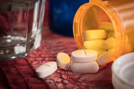 White Pills spilling from an open ambar bottle