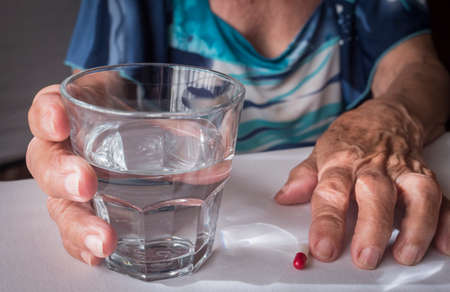 Oldster taking daily medication dose at home, Andalusia, Spainの写真素材