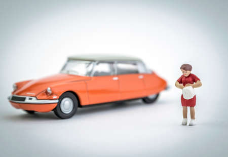 Figure miniature a woman has just parked its orange vintage car