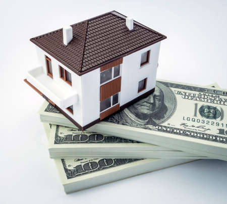 House on a scale on American bills isolated on white backgroundの写真素材