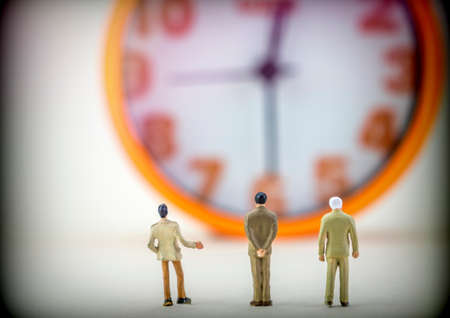 Miniature figures business men front insulated watch on white background, conceptual imageの写真素材