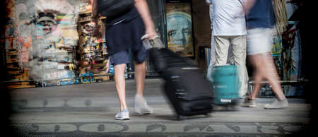 Several travelers with suitcases moving fast in station, conceptual image