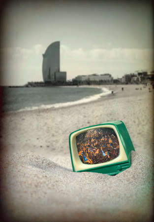 An old television in the beach of Barcelona while manifested people in Catalonia by the Independenceの写真素材