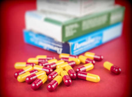 Some capsules red and yellow, boxes of medicines