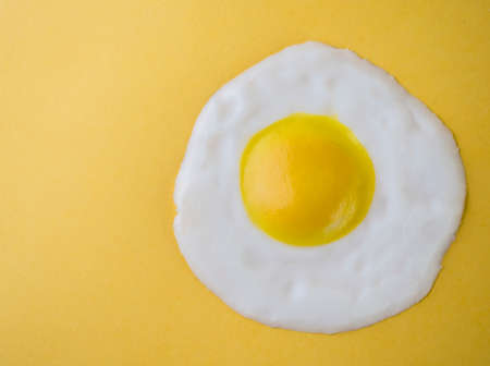 Fried egg isolated on a yellow backgroundの写真素材
