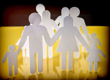 Family silhouettes with children isolated on yellow background, conceptual imageの写真素材