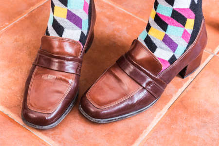 Woman putting on shoes to him vintage with colors socksの写真素材