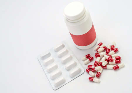 Some capsules of white and red color along with a closed boat