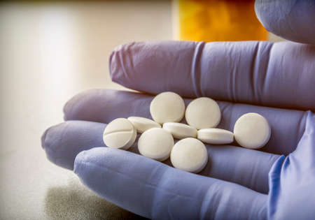 Doctor supports in its hand some white pills