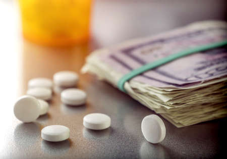 Some white capsules along with tickets of dollar, conceptual image