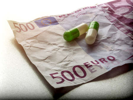Two capsules of white and green on a ticket used 500 euros, conceptual imageの写真素材