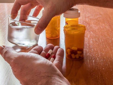 Person Taken Its Daily Medication With A Water Glass