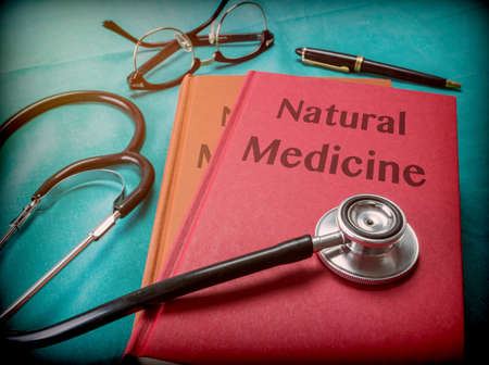 Doctor supports a book of natural medicine in a medical laboratoryの写真素材