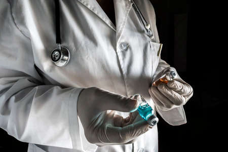 Doctor holds two vials in a hospital. Conceptual imageの写真素材