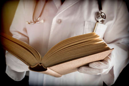 Doctor reads medical book in a hospital. Conceptual imageの写真素材