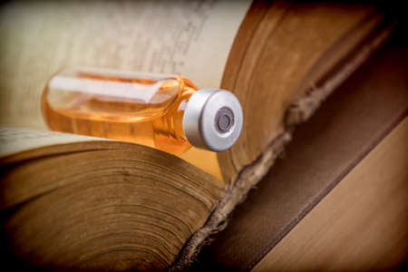 Vial On An Old Book Of Medicine, Conceptual Imageの写真素材
