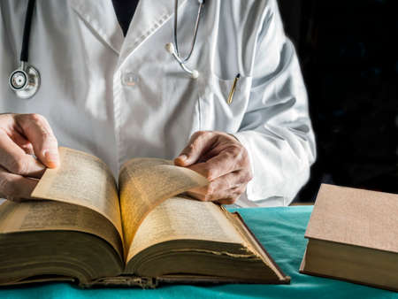 Doctor writes on a book of ancient medicine, conceptual imageの写真素材