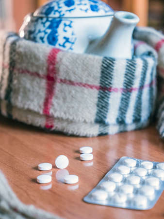 A scarf surrounds to a teapot along with capsules, concept palliative careの写真素材