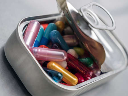 Tin metal contains white pills and red, conceptual image
