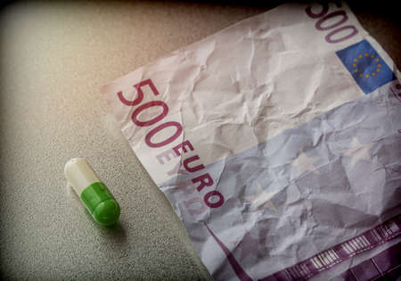 Capsule of white and green on a ticket used 500 euros, conceptual imageの写真素材