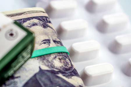 Dollar bills along with white pill package, conceptual image co-payment healthの写真素材