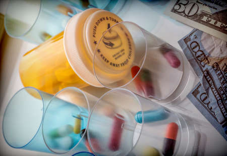 Some medicines next to a block of tickets of dollar, conceptual imageの写真素材