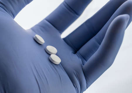 Doctor supports in its hand some white pills