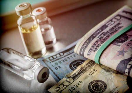 vials with different substances over dollar, concept of copaymentの写真素材