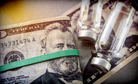 vials with different substances over dollar, concept of copaymentの写真素材