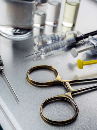 Surgical scissors along with several roads to be injected into a hospitalの写真素材