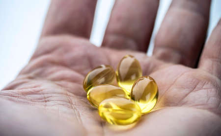 Hand supports several capsules of oil of fish, conceptual imageの写真素材