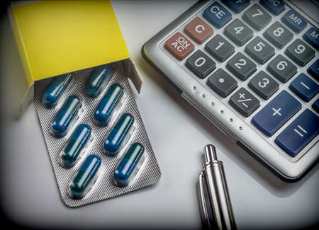 Blister pack of pills next to a calculator, concept of copayment healthの写真素材